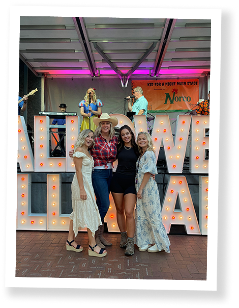  Women and girls in front of lighted sign