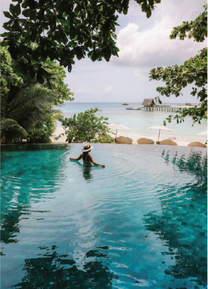 Vacationer in tropical infinity pool