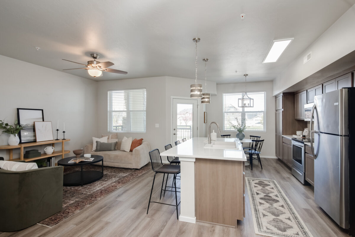 Modern open-concept kitchen and living area with stylish wood-look flooring. This CBH Homes space showcases durable and easy-to-maintain flooring, perfect for busy households. Learn more about flooring maintenance tips to keep your home looking fresh and beautiful.