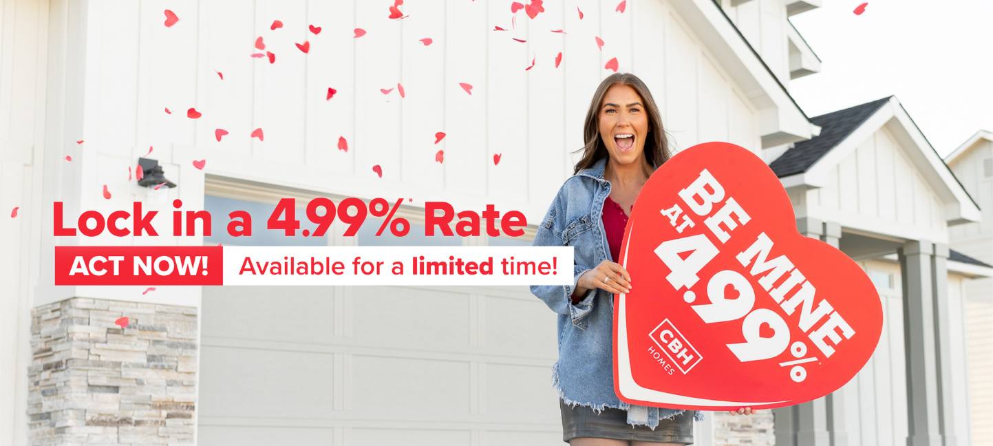 A cheerful woman stands in front of a modern white house, holding a large red heart-shaped sign that reads "BE MINE AT 4.99%." Red rose petals float in the air, creating a festive and romantic atmosphere. Bold red and white text overlays the image, promoting a special mortgage rate offer: "Lock in a 4.99%* Rate. ACT NOW! Available for a limited time!" The ad emphasizes urgency and excitement, likely as part of a Valentine's-themed home-buying promotion from CBH Homes.