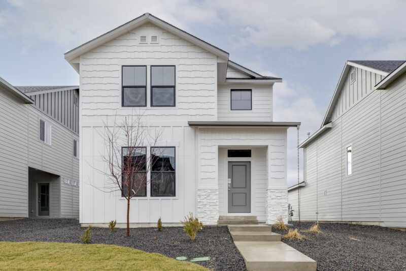 "Front exterior of the Selkirk 1697 floor plan by CBH Homes – a stylish two-story home with crisp white siding, modern black-trimmed windows, and clean curb appeal in the Foxcroft community.